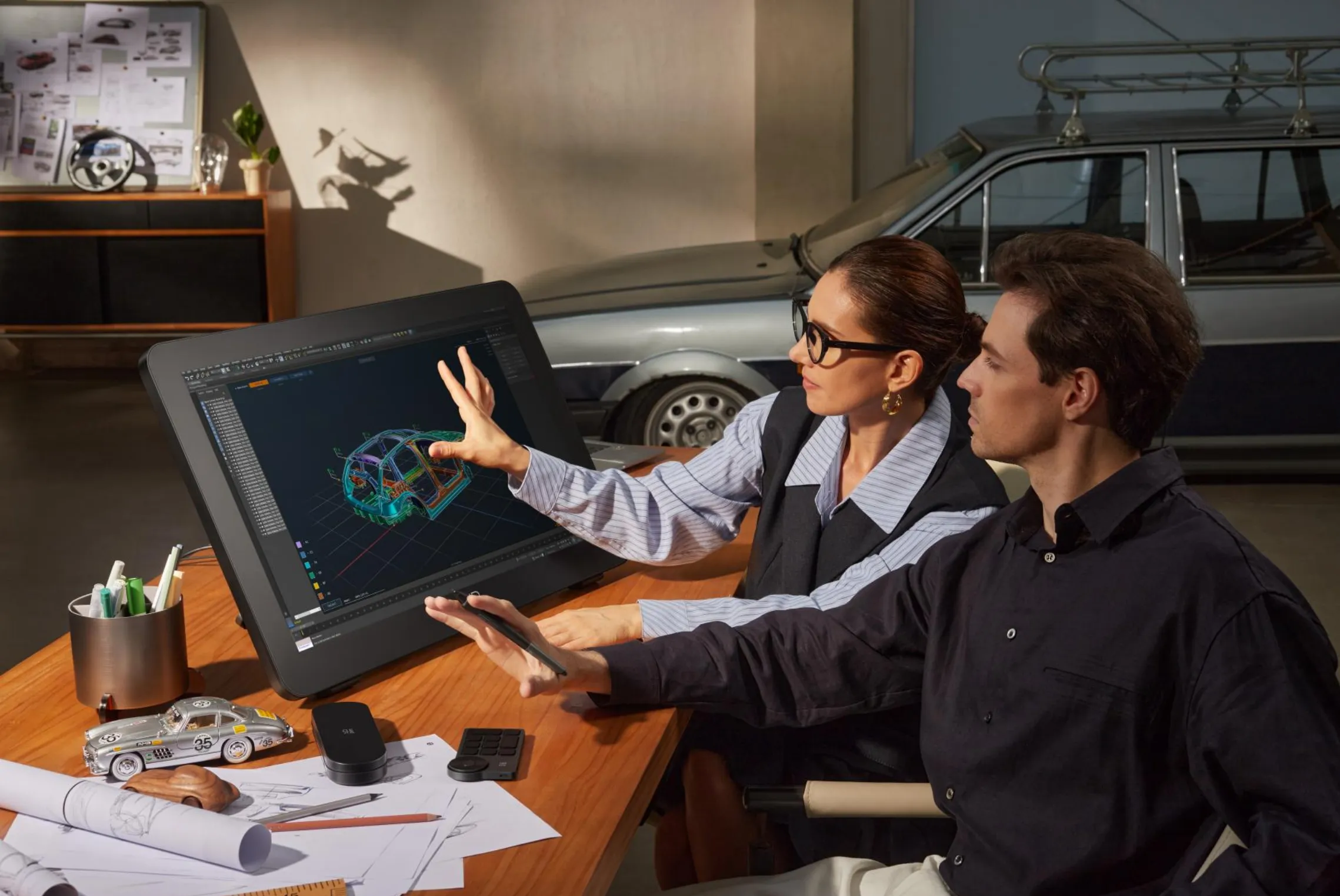 Artist Pro 27 (Gen 2) en estudio de diseño 3D automotriz — tableta gráfica con pantalla 4K de 27 pulgadas mostrando modelo 3D de automóvil